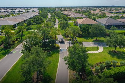 Scenic view of the Paseo Greenway in GL Homes’ Riverland community in Port St. Lucie, featuring a landscaped walking path.